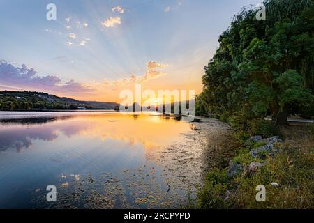 Coucher de soleil sur le lac Kir. Reflets du soleil dans l'eau. Tramonto sul lago Kir... Riflessi del sole nell'acqua. Foto Stock