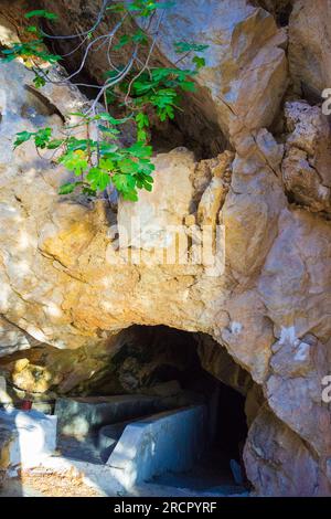 Pietre colorate della grotta Zoodochos Pigi. La sorgente naturale nella grotta è l'unica fonte di acqua dolce sull'isola di Santorini. Grecia Foto Stock