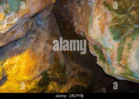 Pietre colorate della grotta Zoodochos Pigi. La sorgente naturale nella grotta è l'unica fonte di acqua dolce sull'isola di Santorini. Grecia Foto Stock