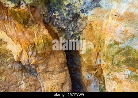 Pietre colorate della grotta Zoodochos Pigi. La sorgente naturale nella grotta è l'unica fonte di acqua dolce sull'isola di Santorini. Grecia Foto Stock