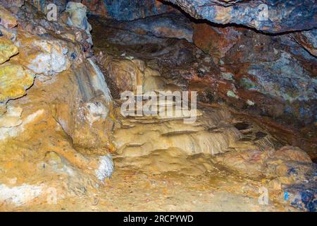 Pietre colorate della grotta Zoodochos Pigi. La sorgente naturale nella grotta è l'unica fonte di acqua dolce sull'isola di Santorini. Grecia Foto Stock