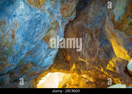 Pietre colorate della grotta Zoodochos Pigi. La sorgente naturale nella grotta è l'unica fonte di acqua dolce sull'isola di Santorini. Grecia Foto Stock