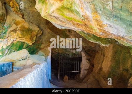 Pietre colorate della grotta Zoodochos Pigi. La sorgente naturale nella grotta è l'unica fonte di acqua dolce sull'isola di Santorini. Grecia Foto Stock