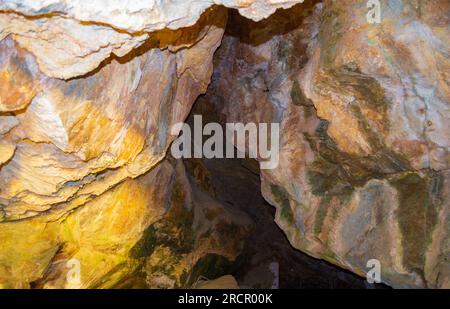 Pietre colorate della grotta Zoodochos Pigi. La sorgente naturale nella grotta è l'unica fonte di acqua dolce sull'isola di Santorini. Grecia Foto Stock