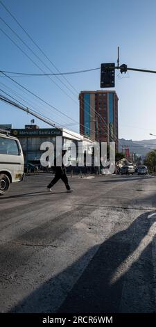 La Paz, la Paz, Bolivia – 12 agosto 2022: Silhouette of a Young Man Crossing the Streets Below Traffic Lights Foto Stock