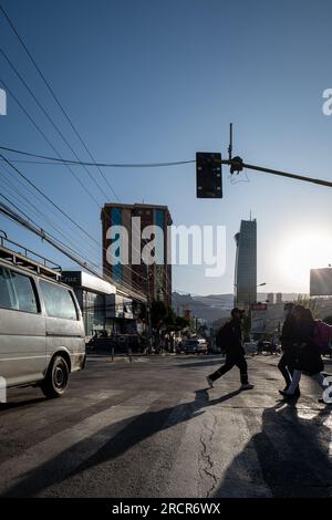 La Paz, la Paz, Bolivia - 12 agosto 2022: Strada con alcune automobili e alcuni giovani che passano di qui nel pomeriggio Foto Stock