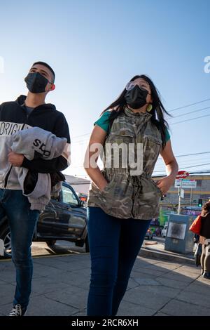 La Paz, la Paz, Bolivia – 12 agosto 2022: Giovani indigeni camminano per le strade con il sole alle spalle Foto Stock