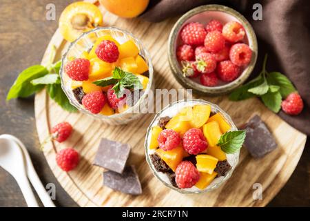 Colazione estiva con dieta salutare, concetto di snack. Triffle di biscotti al cioccolato con yogurt, frutti di bosco freschi e frutta. Parfafait des con due porzioni di vetro Foto Stock