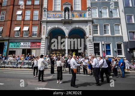 Londra, Regno Unito. 16 luglio 2023. Un'orchestra all'esterno della chiesa italiana di San Pietro davanti alla Processione di nostra Signora del Carmelo, a partire dalla chiesa italiana di San Pietro e poi per le strade di Clerkenwell. I carri allegorici riportano raffigurazioni a grandezza naturale di scene bibliche in un festival cattolico romano che si svolge ogni anno dagli anni '1880 nella zona che un tempo era la piccola Italia della capitale. Crediti: Stephen Chung / Alamy Live News Foto Stock