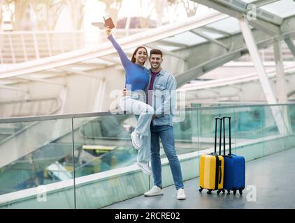Felice coppia di turisti che si presentano con i pass d'imbarco alla stazione degli autobus Foto Stock