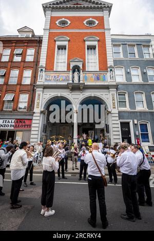 Londra, Regno Unito. 16 luglio 2023. Un'orchestra all'esterno della chiesa italiana di San Pietro davanti alla Processione di nostra Signora del Carmelo, a partire dalla chiesa italiana di San Pietro e poi per le strade di Clerkenwell. I carri allegorici riportano raffigurazioni a grandezza naturale di scene bibliche in un festival cattolico romano che si svolge ogni anno dagli anni '1880 nella zona che un tempo era la piccola Italia della capitale. Crediti: Stephen Chung / Alamy Live News Foto Stock