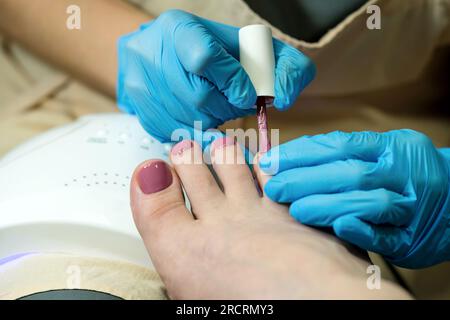 Pedicure. Chiropody. Rivestimento con base colorata per applicazione di pasta abrasiva a gel Foto Stock