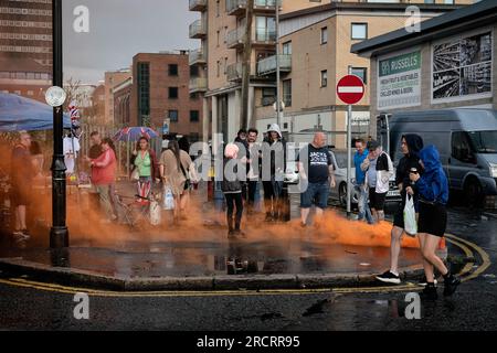 La gente del posto si riunisce per le strade nella zona di Sandy Row a Belfast prima delle celebrazioni dell'undicesima notte. Le pire, costruite con pallet di legno e talvolta pneumatici e altri materiali, sono costruite in tutta l'Irlanda del Nord nei quartieri protestanti per l'annuale 11 luglio, o celebrazioni dell'undicesima notte per commemorare la conquista guglielamita degli anni '1690, che ha dato inizio all'ascendenza protestante in Irlanda. Le pire sono generalmente adornate con il tricolore irlandese e altre regalia o simboli associati al nazionalismo irlandese e all'identità come provocazione verso le comunità cattoliche Foto Stock