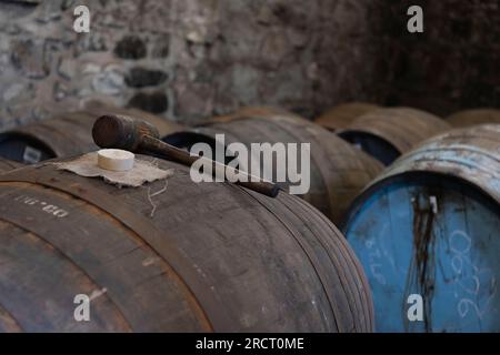 Un mazzuolo di legno con un pioppo Bung e un panno di Hessian Bung in cima a una Whisky Cask in un magazzino presso la Royal Lochnagar Distillery nell'Aberdeenshire Foto Stock