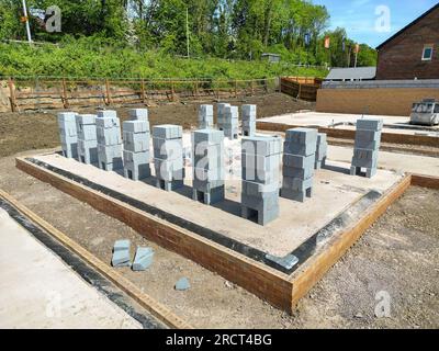 Pontypridd, Galles, Regno Unito - 20 maggio 2023: Pile di blocchi di cemento sulla fondazione di una nuova casa su un nuovo sviluppo abitativo da Bellway Homes Foto Stock