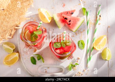 Gustosa limonata con ghiaccio tritato e frutta in un barattolo. Bevanda ghiacciata in un barattolo. Foto Stock