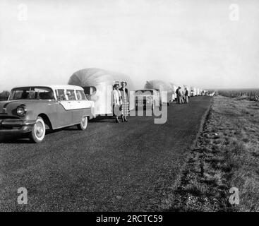 Stati Uniti: 1956 Una linea di rimorchi Airstream a perdita d'occhio parcheggiati su una strada di campagna. Foto Stock