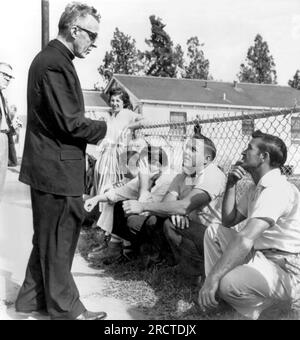 New Orleans, Louisiana: 28 novembre 1960 Un prete cattolico affronta i perturbatori della William Frantz Elementary School durante i suoi primi giorni di integrazione. Il prete è stato ingannato e spinto per i suoi sforzi. Foto Stock