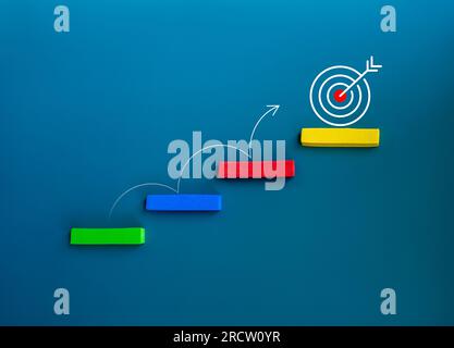 Freccia a linea curva che salta su gradini colorati dal basso all'icona del bersaglio sul blocco superiore su sfondo blu, stile minimalista. Obiettivo aziendale e. Foto Stock