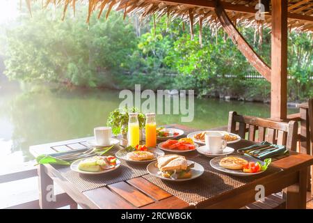 Gustate una colazione tropicale vicino al lago in un resort asiatico. Foto Stock