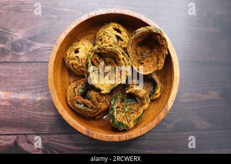 La patra secca è un piatto indiano a base di foglie di colocasia ricoperte da un impasto piccante di farina e fritto in profondità. E' un piatto popolare in Gujarat. Foto Stock