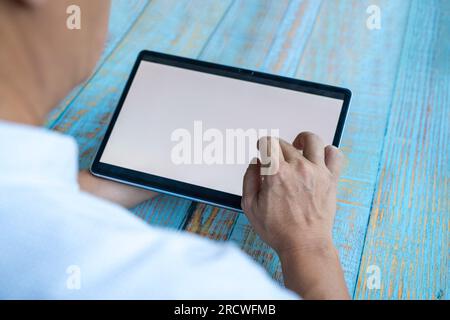 Uomo che utilizza un tablet digitale tramite touchscreen. Copia spazio. Foto Stock