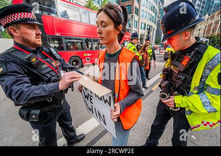 Londra, Regno Unito. 17 luglio 2023. L'alto ufficiale di polizia presente li avverte sotto la sua azione di ordine pubblico e tre (che non lasciano la strada) vengono arrestati e portati alla stazione di polizia di bishopsgate - la protesta dura meno di 15 minuti e causa un disturbo minimo. Basta fermare la protesta petrolifera su Bishopsgate viene rimossa rapidamente dalla polizia della città di Londra (in parte perché il loro quartier generale è a soli 100 metri di distanza). L'obiettivo generale del gruppo è quello di convincere il governo a fermare tutti i nuovi giacimenti petroliferi. come parte dello sforzo per cercare di evitare la crisi climatica. Crediti: Guy Bell/Alamy Live News Foto Stock