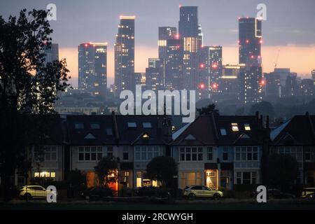 Portici illuminati di case d'epoca terrazzate e in lontananza, il crescente sviluppo a Nine Elms a Battersea, visto da Ruskin Park, uno spazio verde a sud di Londra a Lambeth, il 16 luglio 2023, a Londra, in Inghilterra. Foto Stock