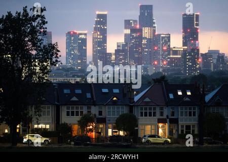 Portici illuminati di case d'epoca terrazzate e in lontananza, il crescente sviluppo a Nine Elms a Battersea, visto da Ruskin Park, uno spazio verde a sud di Londra a Lambeth, il 16 luglio 2023, a Londra, in Inghilterra. Foto Stock