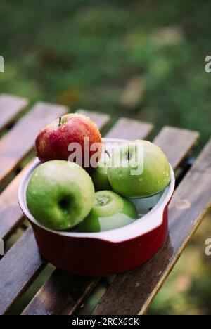 Mele in un recipiente con acqua. Foto Stock