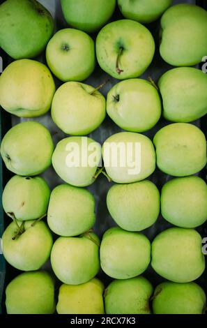 Mele verdi in una cassa. Vendite sul mercato della frutta. Foto Stock