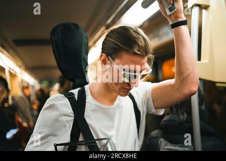 cantante nel treno della metropolitana che va a lavorare con gli intrumenti della musica Foto Stock