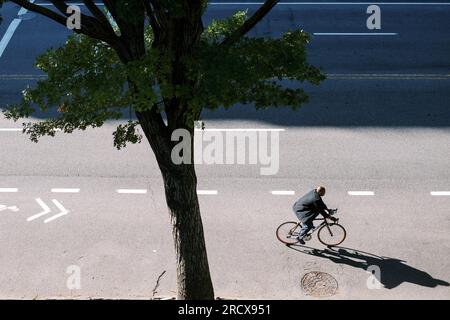 uomo in bicicletta nella corsia ciclabile, girato dall'alto Foto Stock