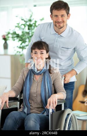 Amorevole marito abbracciando handicappati moglie a casa Foto Stock