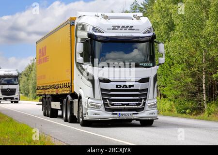 Nuovo veicolo DAF XG+ 530 bianco personalizzato di Salon Logistiikka Oy davanti al semirimorchio DHL sull'autostrada 25. Raasepori, Finlandia. 7 luglio 2023. Foto Stock