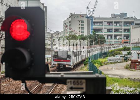 Un treno della metropolitana MTR viene guidato sul binario durante il segnale di avvertimento n. 8. Nelle prime ore del 17 luglio, quando il tifone Talim si avvicina a Hong Kong, l'Osservatorio di Hong Kong emette il segnale di allarme del tifone n. 8 alle 00:40 del mattino Questo segnale porta cambiamenti significativi in tutta la città, con la maggior parte dei servizi di autobus che si fermano e il mercato azionario chiude le porte in risposta al pericolo imminente. Tuttavia, in mezzo a queste misure precauzionali, la MTR (Mass Transit Railway) continua a fornire servizi di metropolitana limitati, garantendo che residenti e viaggiatori abbiano un mezzo di trasporto durante Foto Stock