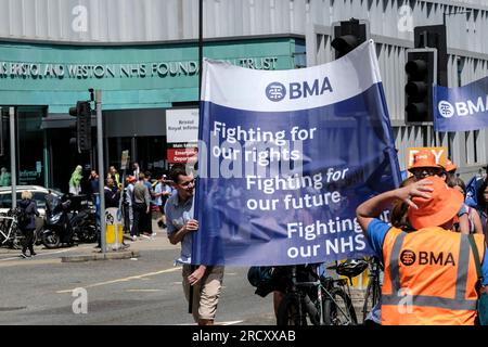 Bristol, Regno Unito. 17 luglio 2023. I giovani medici marciano dalla Royal Infirmary di Bristol per segnare la fine del quarto round del loro sciopero. L'azione industriale sostenuta dalla BMA e dall'HCSA promuove la richiesta di retribuzione del Dottore, che mira a ripristinare il reddito perso da anni di aumento delle retribuzioni al di sotto dell'inflazione. Anche se il governo ha offerto un aumento del 6,5%, i medici continuano a protestare perché l'ultima offerta non risponde alla loro necessità di ripristino delle retribuzioni. Crediti: JMF News/Alamy Live News Foto Stock