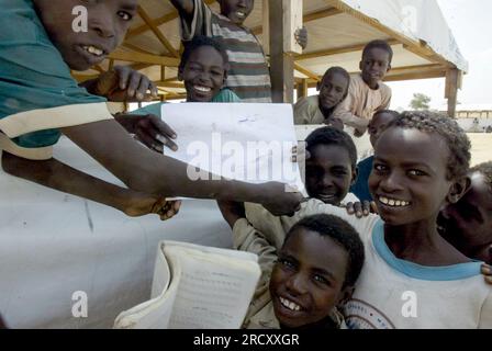 Giovani rifugiati sudanesi in una scuola improvvisata nel campo profughi di Kolongo nel Ciad orientale, 1° agosto 2004 Foto Stock