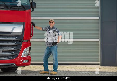 Euro Trucker professionale e il suo nuovo semitrattore. Settore dei trasporti per impieghi gravosi. Foto Stock