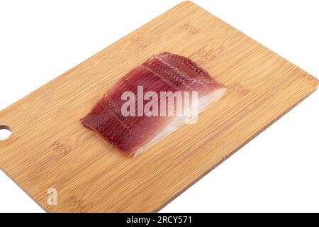 Delizioso jamon a fette sottili su un tagliere su sfondo bianco. Copia spazio. Foto Stock