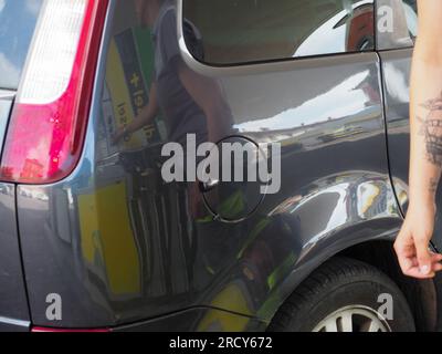 Cremona, Italia - 3 luglio 20223 donna che assiste un cliente presso una moderna pompa di benzina presso la stazione di servizio Eni Agip Foto Stock