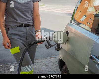 Cremona, Italia - 3 luglio 20223 donna che assiste un cliente presso una moderna pompa di benzina presso la stazione di servizio Eni Agip Foto Stock