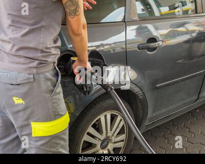 Cremona, Italia - 3 luglio 20223 donna che assiste un cliente presso una moderna pompa di benzina presso la stazione di servizio Eni Agip Foto Stock