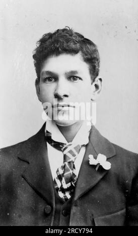 Ritratto testa e spalla di un giovane che indossa una cravatta e ha un fiore nel risvolto. Fotografia originale non attribuita. Da una collezione di fotografie vittoriane carte de visite, datate al 1890 Carte de visite è un termine francese conosciuto in inglese come "carta da visita". Di solito avevano una stampa fotografica in albume di circa 54x89 mm montata su una scheda leggermente più grande. In alcuni casi, le devastazioni del tempo hanno preso il loro tributo. Foto Stock