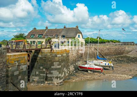 Porlock Weir nel Somerset, Inghilterra occidentale in estate, con un muro del porto, splendidi cottage con tetto in paglia, yacht ormeggiati in una giornata estiva nel mese di Ju Foto Stock