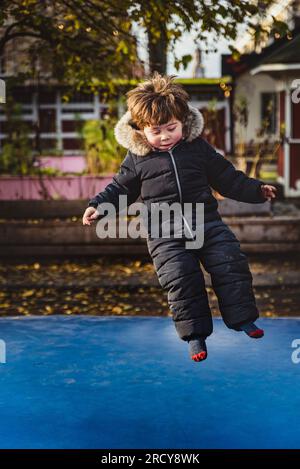 Ragazzo che vola, salta contro la gravità. I capelli del bambino in aria: Il ragazzo sfida la forza gravitazionale. Il bambino in età prescolare fluttua allegro Foto Stock