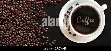 Caffè americano. Vista dall'alto di una tazza di caffè sullo sfondo dei chicchi di caffè tostati. Il caffè in una tazza bianca. Banner Foto Stock