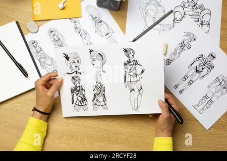 L'artista disegna personaggi di carta per giochi per computer o fumetti. Foto Stock