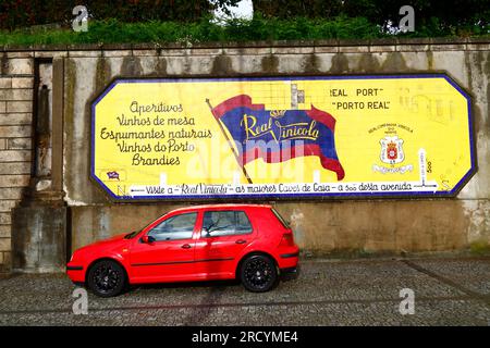 Auto rossa parcheggiata di fronte a un annuncio in piastrelle di ceramica per la società vinicola Real Companhia Vinícola do Norte, Vila Nova de Gaia, Portogallo Foto Stock