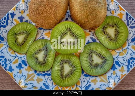 Fette di kiwi su un piatto colorato Foto Stock